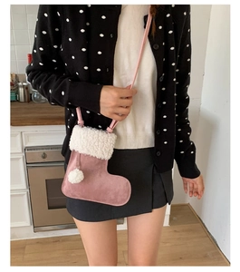 Detail of pink Christmas stocking shoulder bag with white faux fur trim and pom-pom