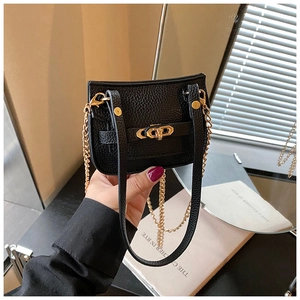 Détail d'un mini sac bandoulière noir en cuir grainé avec un fermoir rotatif doré