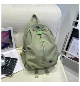 Detail of light green nylon kids backpack with vertical zipper and water bottle pocket