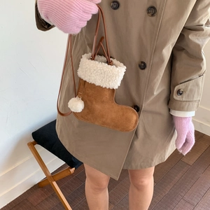 Détail du sac bandoulière botte de Noël en daim marron avec bordure en fausse fourrure