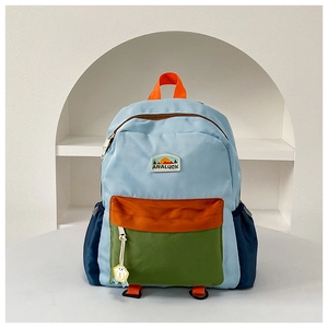 Detail of color-block nylon school bag featuring adjustable straps and durable side pockets