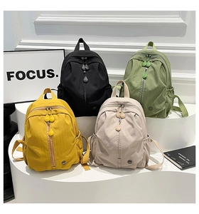 Detail view of colorful nylon backpacks with vertical zippers and drawstring pockets