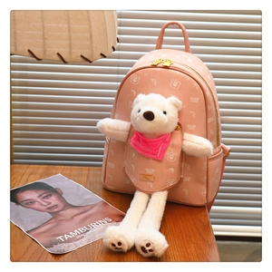 Detail of pink leather backpack featuring a 3D plush white bear and metal logo plate