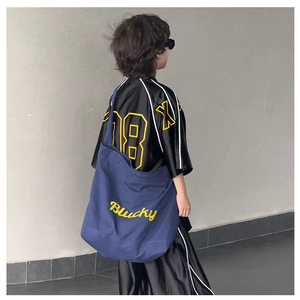Détail du cabas en toile bleu marine avec broderie Blucky jaune et photo de mannequin