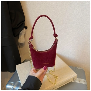 Détail du mini sac bordeaux en daim avec chaîne dorée et inscription à la mode