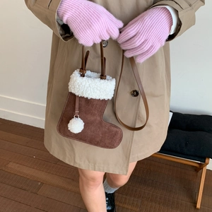 Détail du sac à bandoulière en forme de botte de Noël avec bordure en fourrure et pompon