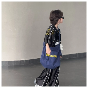Détail du grand sac bandoulière en toile pour enfant avec pendentif ours et imprimé lettres