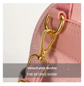 Detail showing high-quality gold metal lobster clasp on pink printed canvas backpack strap