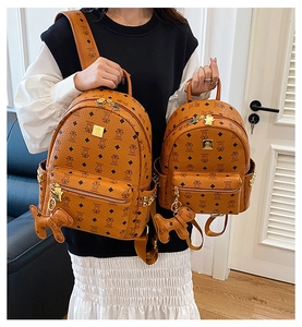 Detail of brown bear print backpacks in two sizes with gold studs and bear charms