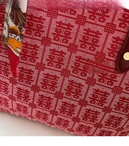 Detail of red festive tote with Xi jacquard fabric and decorative silk scarf accent