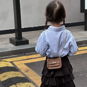 Tenue fillette avec chemise rayée bleue, jupe à volants noire et mini sac à bandoulière