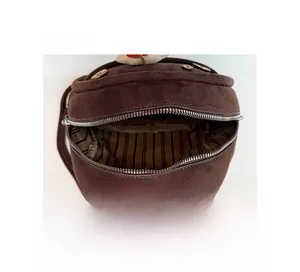 Detail view of mini brown bag interior featuring black and white vertical striped lining