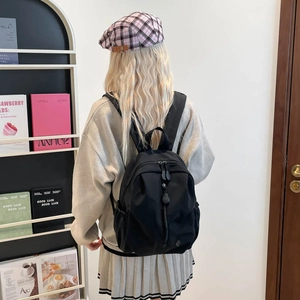 Minimalist black student backpack with large capacity and durable waterproof nylon fabric