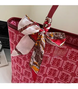 Detailed shot of red woven bridal tote bag with Xi character and decorative silk scarf