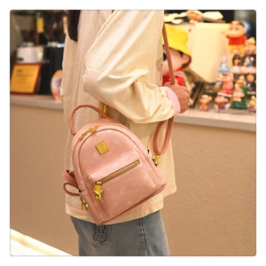 Detail of pink mini backpack featuring cute cartoon bear prints and golden metal zippers
