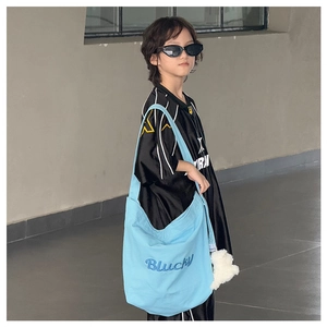 Détail du sac fourre-tout en toile bleu clair avec broderie Blucky et bandoulière