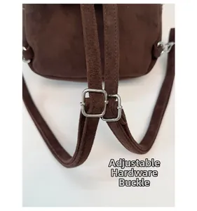 Detail of adjustable silver buckles on dark brown faux suede backpack shoulder straps