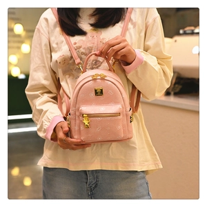 Close-up of pink mini backpack with bear prints and golden metallic hardware