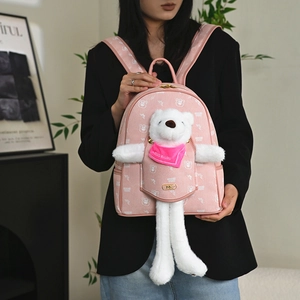 Pink girls backpack featuring a plush white bear charm and stylish metallic logo