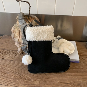 Détail du sac botte de Noël en daim noir mat avec bordure en fausse fourrure blanche