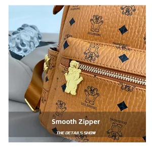 Close-up of smooth bear-shaped zipper pull and textured brown leather on student backpack