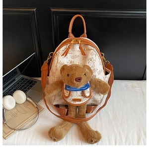 Close-up of white PU leather backpack featuring cute brown plush bear and letter prints