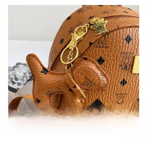 Detail of lychee pattern leather backpack with a dog-shaped charm and gold metal zipper