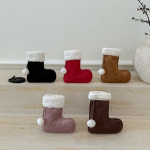Gros plan de cinq chaussettes de Noël en daim avec bordure en fourrure sur marbre