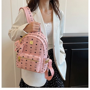 Close-up of pink backpack with bear pattern, litchi grain texture, and cute charm