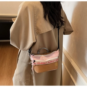 Detail of pink and khaki crossbody bag with 'Fashion' embroidery and decorative webbing