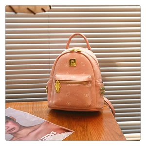 Detail shot of mini pink backpack with cartoon bear print and golden studded side pockets