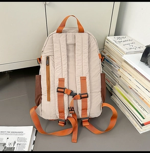 Detalle de mochila multicolor con correas naranjas y bolsillo trasero antirrobo