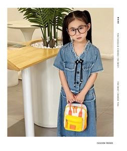 Dettaglio della mini borsa bicolore giallo e bianco con abbigliamento denim