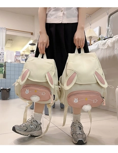 Close-up of Japanese style girl backpack with cute bunny ears and soft plush ball charm