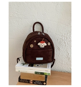 Detail of dark brown suede mini backpack with cartoon dog patch and button accents