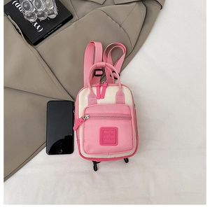Mini zaino rosa e crema con smartphone come riferimento per le dimensioni e stile moda