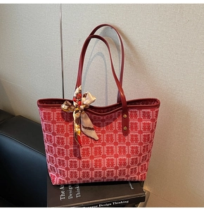 Detail of red festive tote bag featuring Xi character jacquard and silk scarf handle