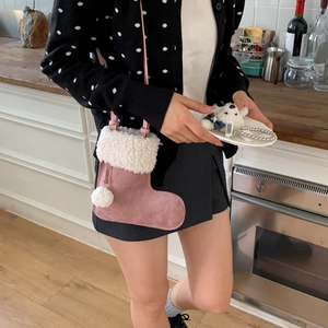 Sac à bandoulière rose en daim en forme de botte avec fourrure blanche sur mannequin