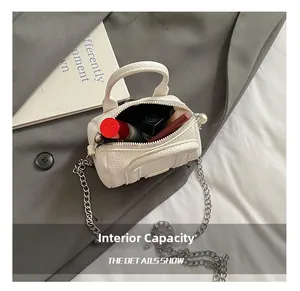 Internal capacity of mini white cylinder bag showing lipstick and leather texture