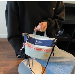 Detail of multi-color canvas crossbody bag featuring fashion embroidery and strap texture