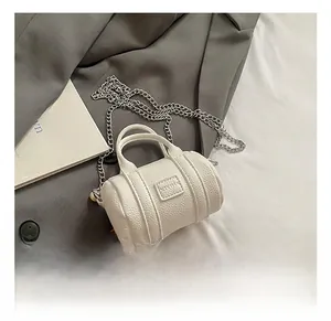 Detail of white mini barrel bag featuring lychee texture and silver chain strap