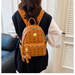 Close-up of brown synthetic leather backpack with cute bear prints and metal rivet details