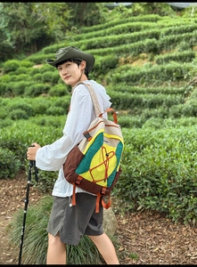 Senderista con mochila de montaña multicolor en una plantación de té verde de estilo japonés