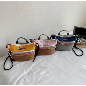 Three colorful canvas crossbody bags with Fashion embroidery shown in a flat lay view