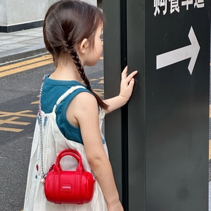 Mini red Boston bag for children with silver chain strap shown on child model