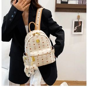 On-body view of mini backpack featuring bear print and elephant charm accessory