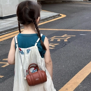 Minimalist brown cylindrical toddler handbag with silver chain strap and XIXIHA logo