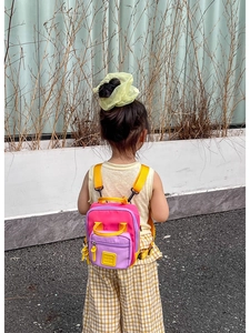 Dettaglio mini zaino per bambini color-block con pannelli a contrasto rosa viola e giallo