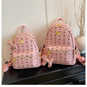 Detail of pink faux leather backpacks with bear print and golden studs decoration