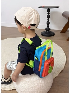 Dettaglio dello zaino mini per bambini con vivaci pannelli colorati blu e arancioni